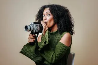 a woman holding a camera and looking at it